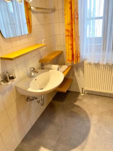 a bathroom with a white sink and a window at Gästehaus Schwed in Wagrain