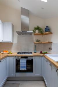 a kitchen with white cabinets and a stove top oven at Number 40 in Kingsbridge