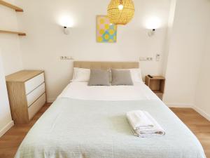 a bedroom with a large white bed with a towel on it at Cosy beach suite Agata in Benalmádena