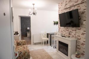 a living room with a fireplace and a tv on a brick wall at Urban Oasis in Piatra Neamţ