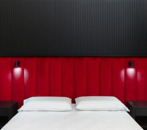 ein Schlafzimmer mit einem roten Kopfteil und einem weißen Bett in der Unterkunft FiDa Rooms in Neapel