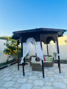a gazebo with a table and chairs under it at Alis Villa in Hurghada