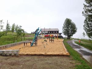 a playground in front of a house with a slide at Ferienwohnung Rigi-Scheidegg Ost in Goldau