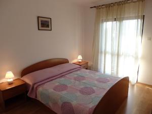 una camera con letto con trapunta e finestra di Apartments Ivan & Ana a Korčula