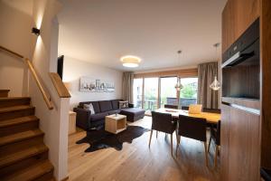 a living room with a couch and a table with chairs at Lakeside Luxury Apartments in Zell am See