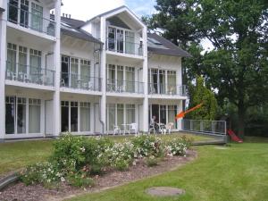 a person playing with a frisbee in front of a house at Villa Granitz - Ferienwohnung Rechtern in Göhren