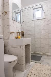 a white bathroom with a sink and a toilet at Urban Oasis in Piatra Neamţ