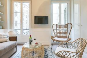 een woonkamer met een bank en stoelen bij Lovely flat in Central Paris near Notre-Dame in Parijs