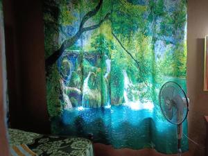 a shower curtain with a painting of a waterfall at Kalidasa Tree House and Villa, Wayanad in Chegāt