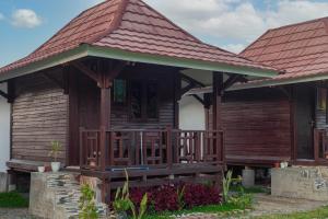 a wooden house with a porch and a roof at Bale Gantar in Sembalun Lawang