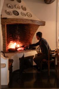 a man sitting at a table in front of a fireplace at Le Prieuré sur Seine in Marnay-sur-Seine