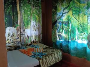 a room with paintings of unicorns on the walls at Kalidasa Tree House and Villa, Wayanad in Chekadi