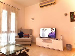 uma sala de estar com uma televisão de ecrã plano e uma cadeira em South marina apartment MS10 Wi-Fi available em Hurghada