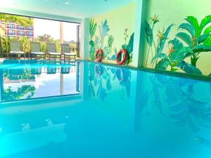a swimming pool with a mural on the wall at Aman Boutique Hotel in Hoi An