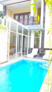 une maison avec une piscine en face d'une maison dans l'établissement Villa Jalak Kembar, à Canggu