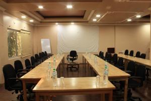 uma sala de conferências com uma mesa longa e cadeiras em The Orchid Hotel em Phuntsholing