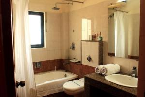 uma casa de banho com uma banheira, um WC e um lavatório. em The Orchid Hotel em Phuntsholing