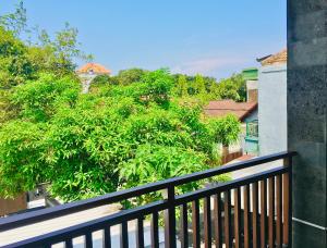 a balcony with a view of a tree at Villa Jalak Kembar in Canggu