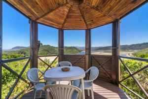a room with a table and chairs on a porch at Sand Castle in Sedgefield