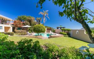 a garden with a swimming pool and a house at Sand Castle in Sedgefield