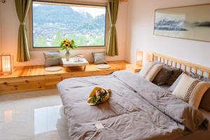 a bedroom with a large bed and a large window at 云起山居庭院观景民宿 in Fenghuang