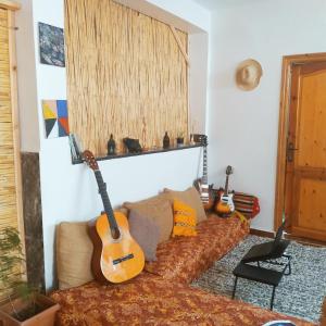 - deux guitares assises sur un canapé dans le salon dans l'établissement Idriss's hostel, à Taghazout