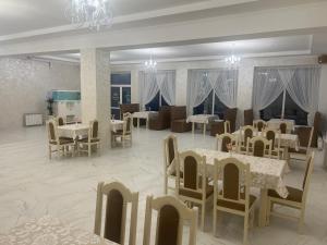 a restaurant with tables and chairs and a dining room at Grand Hotel in Mohyliv-Podilʼsʼkyy