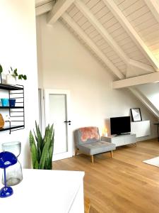 a living room with a chair and a tv at Gemütliches Loft in Geretsried