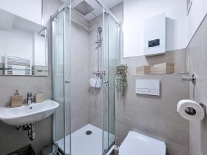 een badkamer met een douche, een toilet en een wastafel bij Alpha Apartments in Dortmund