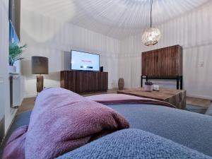 een slaapkamer met een bed en een flatscreen-tv bij Alpha Apartments in Dortmund
