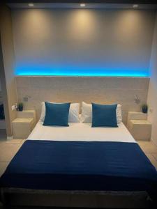 uma cama grande com duas almofadas azuis num quarto em Casa Manfredi - Manfredi Homes&Villas em Manfredonia