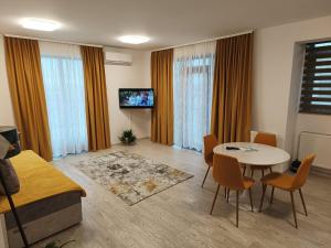 uma sala de estar com uma mesa e cadeiras e uma televisão em Apartament Genius 2 em Ploiesti