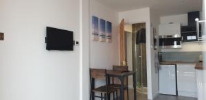 uma cozinha com um frigorífico e uma mesa num quarto em Tiny home whole flat beach cabin em Southwick