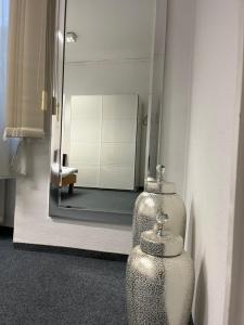a bathroom with a mirror and two vases on the wall at Waldshut Stadt Ferien Wohnung in Waldshut-Tiengen