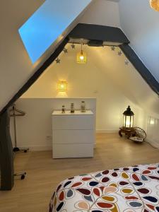 a attic room with a bed and a sink at République in Verberie