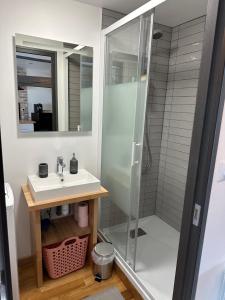 ein Bad mit einer Dusche und einem Waschbecken in der Unterkunft République in Verberie