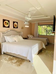 um quarto com 2 camas e uma grande janela em Hope Valley Adventure Resort em Guarapuava