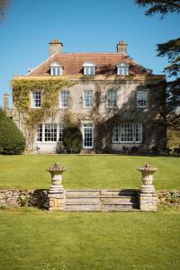 an old house with two stone pillars in front of it at Holbrook Manor & Spa - OCEANA COLLECTION in Wincanton