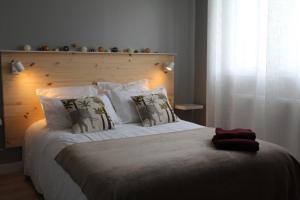 a bedroom with a large bed with a wooden headboard at Le pré du buis in Yvré-lʼÉvêque