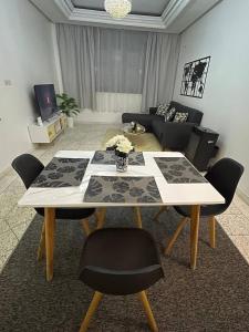 ein Wohnzimmer mit einem Tisch mit Stühlen und einem Sofa in der Unterkunft Chez Siham in Fès