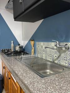 a kitchen counter with a sink and a stove at Chez Siham in Fès