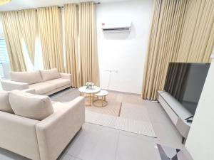 a living room with a couch and a tv at One Sweet Homestay Kulim Hi-Tech utk Msliim shj in Kulim