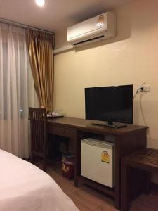 a bedroom with a desk with a television and a bed at Chan Chiangmai House in Chiang Mai