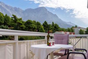 - une table avec deux verres de vin sur un balcon avec des montagnes dans l'établissement Baska Voda Apartment 1, à Baška Voda