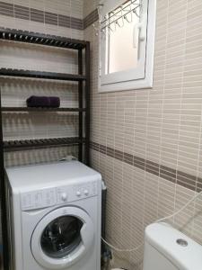 a small bathroom with a washing machine and a toilet at Alicante airport and beach in El Altet