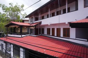 an external view of a building with red roof at SURF UNA BEACH HOTEL in Unawatuna