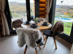 a wooden table with four chairs and a table with fur at Rönk Relax in Miskolc
