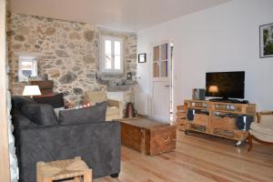 a living room with a couch and a tv at Maison Sottou in Osse-en-Aspe
