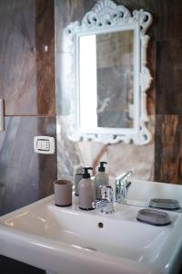 a bathroom sink with two soap bottles on it at La Resilienza Relais in Grumo Nevano +45 photos