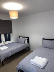 a bedroom with two beds and a light fixture at Spacious 2-Bed Apartment in Oxford in Oxford